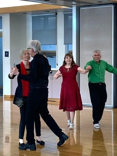 Older adult couples practice steps in a tango dance class.